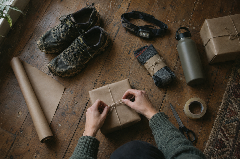 Running gifts being wrapped in brown paper next to muddy trail shoes and a head torch